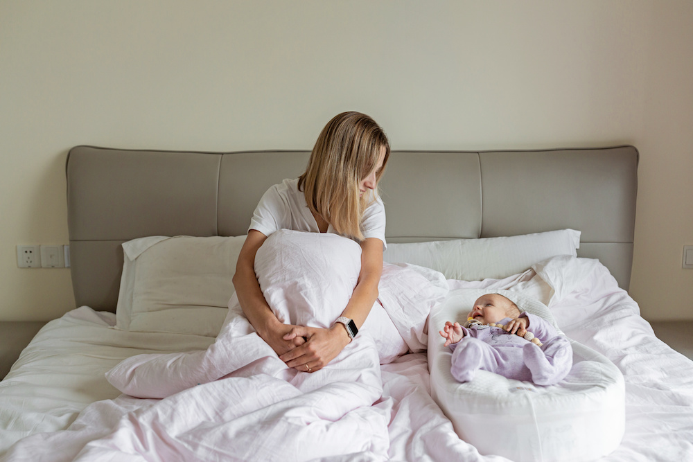 mom and baby in bed at postnatal retreat