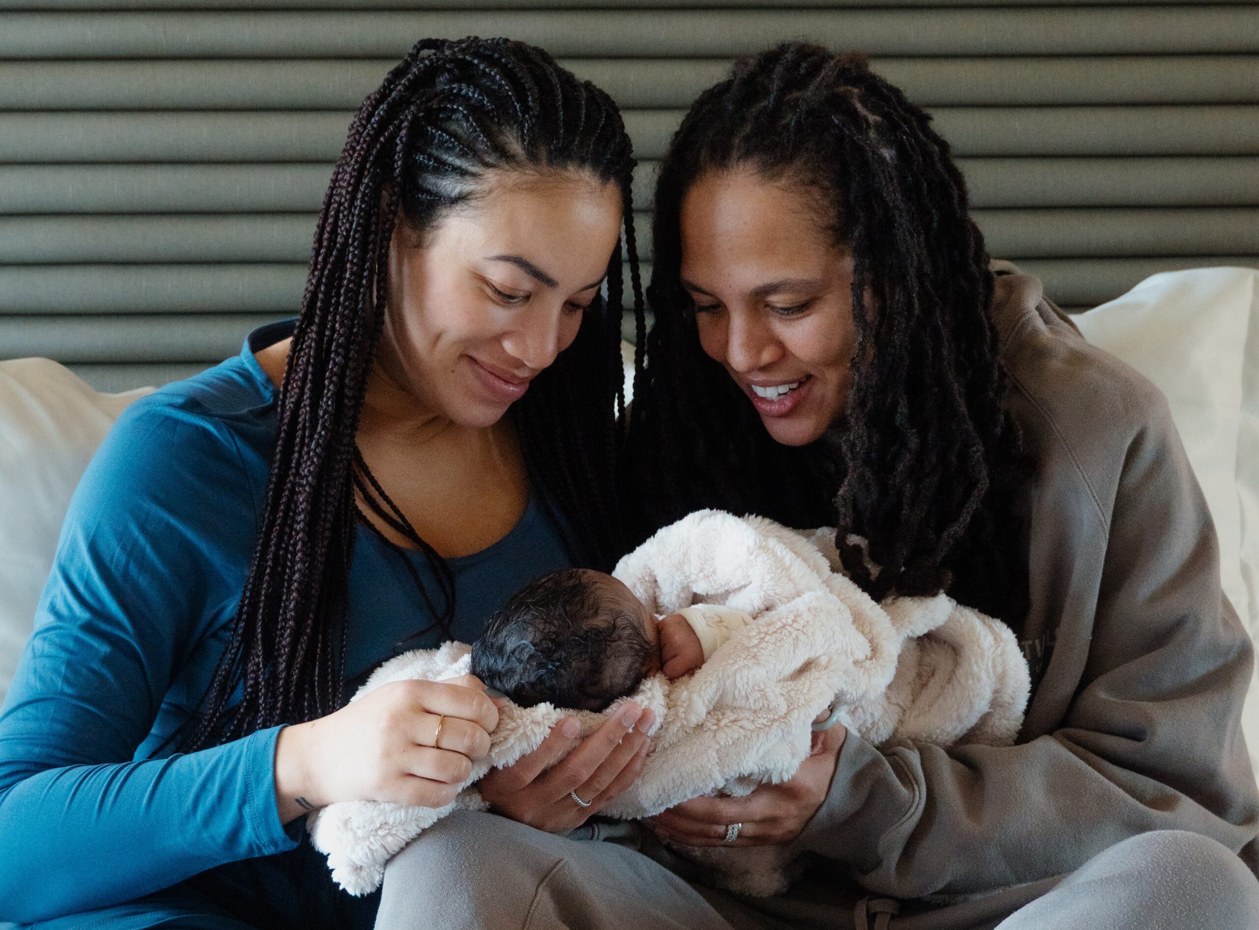 two moms admiring baby